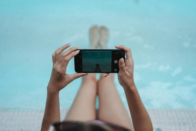 a woman taking a picture of herself in a swimming pool, sleek legs, gen z, fan favorite, pixelated