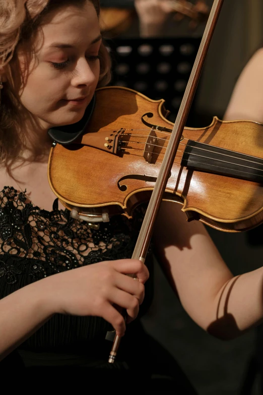 a woman in a black dress playing a violin, close - up photograph, intricate detailing, promo image, rectangle