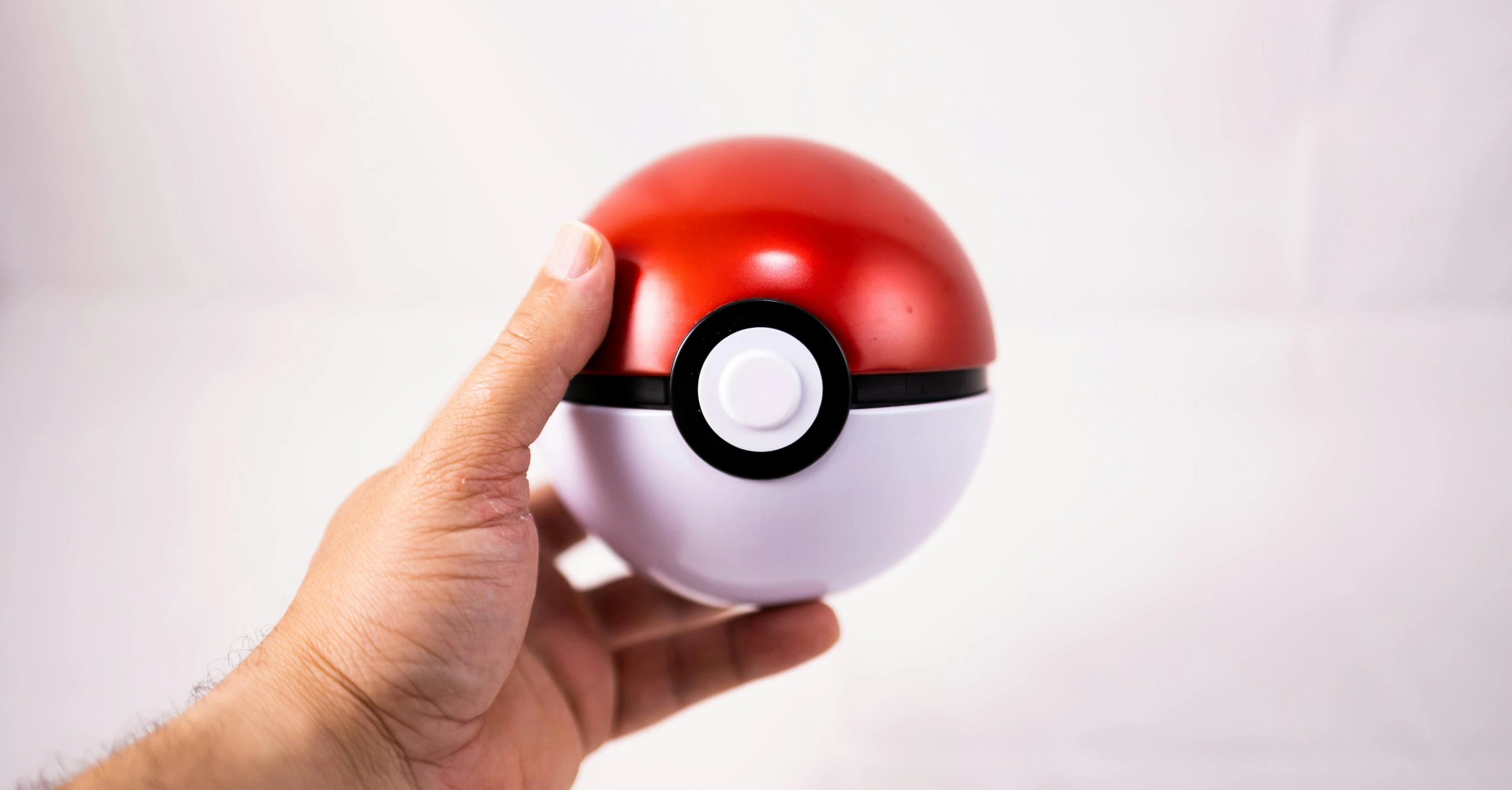 a hand holding a red and white poke ball, trending on pexels, shiny textured plastic shell, battery, magic item, 1 figure only