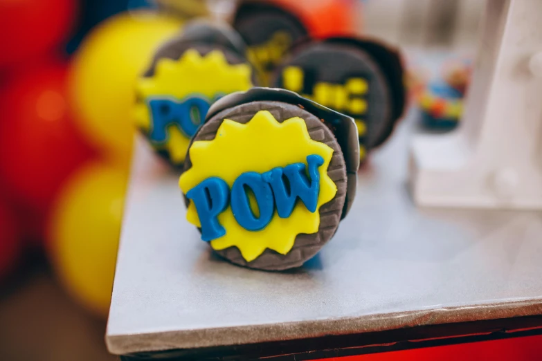 a close up of some cookies on a table, by Emma Andijewska, pexels, pop art, superhero cape, event, yellow, wow