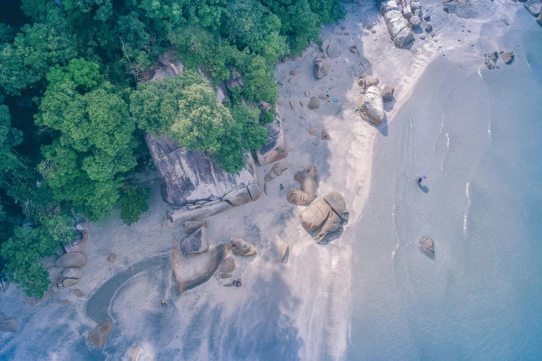 an aerial view of a beach surrounded by trees, by Seb McKinnon, pexels contest winner, visual art, boulders, malaysian, thumbnail, low quality photo