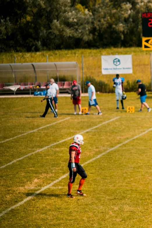 a group of young men playing a game of football, a tilt shift photo, by Sebastian Spreng, unsplash, sumerville game, 2 0 2 2 photo, panoramic, football armor