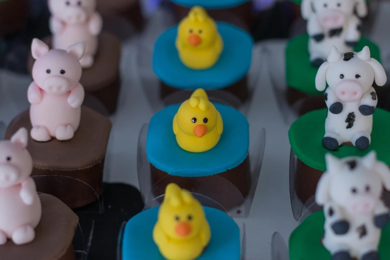 a tray of cupcakes decorated to look like farm animals, a cartoon, inspired by Jacob Duck, pexels, 3 d clay figure, thumbnail, chocolate art, shot on sony a 7