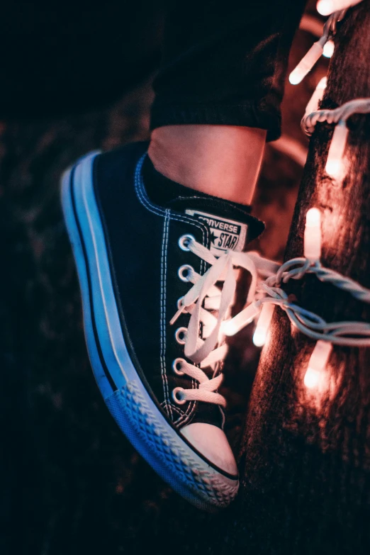 a close up of a person's shoes on a tree, pexels contest winner, lights inside, teenage girl, black and blue, converse