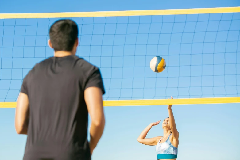a man and a woman playing volleyball on the beach, unsplash, arabesque, high quality product image”, “ iron bark, bright sunny day, towering over your view