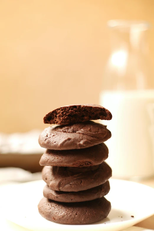 a stack of chocolate cookies sitting on top of a white plate, by Adam Chmielowski, beautiful surroundings, soft, grain”, large tall