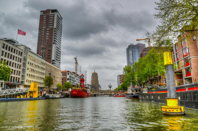 a boat traveling down a river next to tall buildings, by Jan Tengnagel, pexels contest winner, helmond, preserved historical, thumbnail, city docks