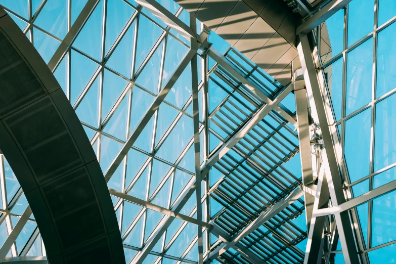 a clock mounted to the side of a glass building, pexels contest winner, light and space, canopies, vaulted ceiling, aquamarine windows, steel archways