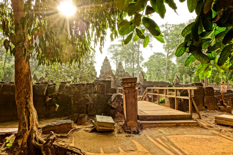 a wooden bridge in the middle of a forest, angkor thon, warm sunlight shining in, buildings carved out of stone, museum photo