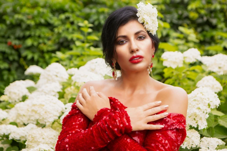 a woman in a red dress with a flower in her hair, ameera al taweel, at a fashion shoot, lush surroundings, square