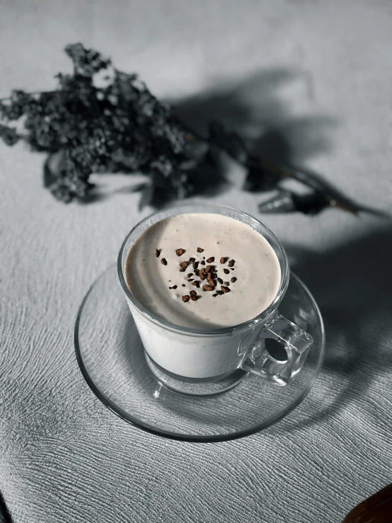 a cup of coffee sitting on top of a table, vanilla smoothie explosion, with grey skin, botanicals, hungarian