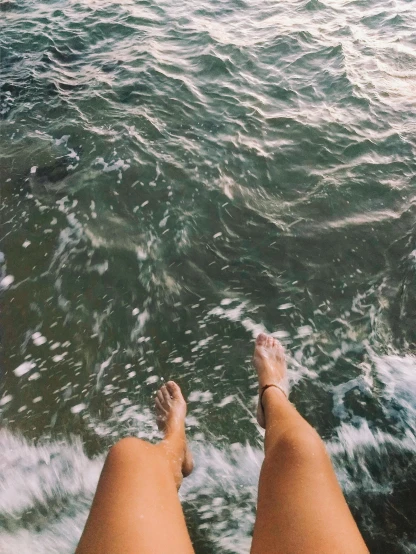 a person standing at the edge of a body of water, barefeet, swimming in ocean, trending on vsco, multiple stories