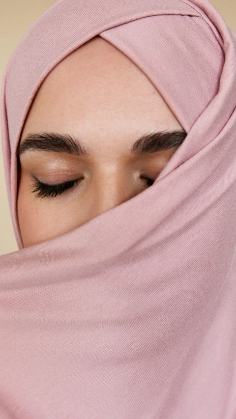 a close up of a woman wearing a pink hijab, trending on pexels, hurufiyya, muted pastels, half - closed eyes, skincare, medium-shot