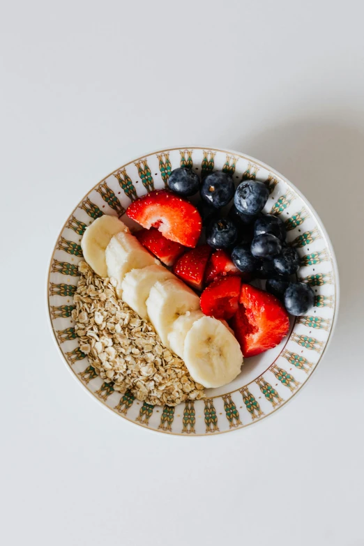 a bowl of oatmeal with bananas, strawberries and blueberries, a portrait, pexels, renaissance, detailed product image, dan mumfor, fruit bowl, cutout