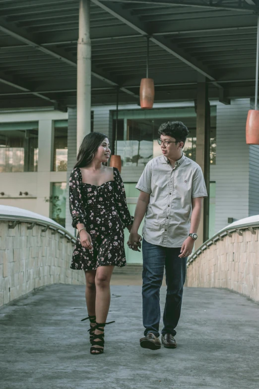 a man and a woman walking across a bridge, a picture, happening, at a mall, half asian, cinematic photo shoot, wearing casual clothing