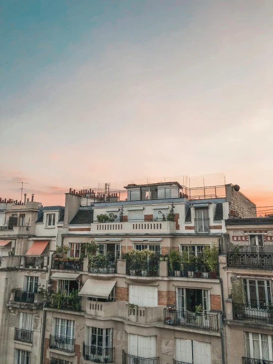 a group of buildings sitting next to each other, pexels contest winner, paris school, golden hour dusk sky, balcony, 1 2 9 7, low quality photo