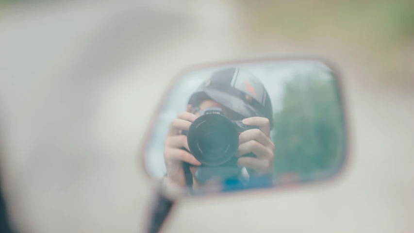 a person taking a picture of themselves in a rear view mirror, unsplash contest winner, photorealism, portrait shot 8 k, minimalist photo, dreamy blurred lens, medium-shot