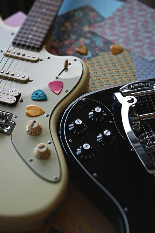 a couple of guitars sitting on top of a table, an album cover, trending on pexels, controllers, paisley, stingray, switches