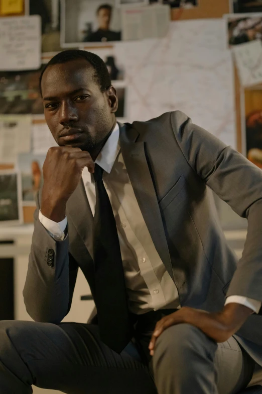 a man in a suit sitting on a chair, dark skin tone, hugo boss prize, **cinematic, architect