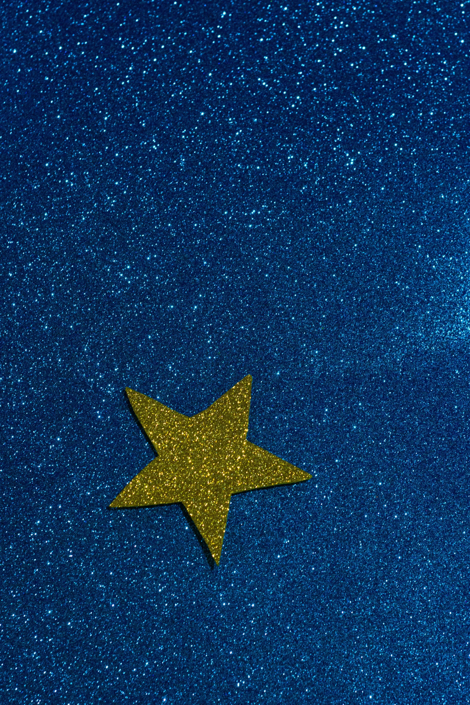 a gold star on a blue background, an album cover, trending on unsplash, symbolism, glitter, navy blue carpet, star charts, holiday season