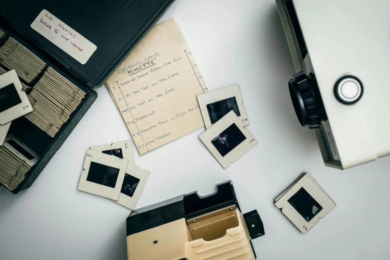 an open suitcase sitting on top of a white table, a polaroid photo, by Everett Warner, unsplash, visual art, old scientific documents, vhs recording, cinema still, high angle close up shot
