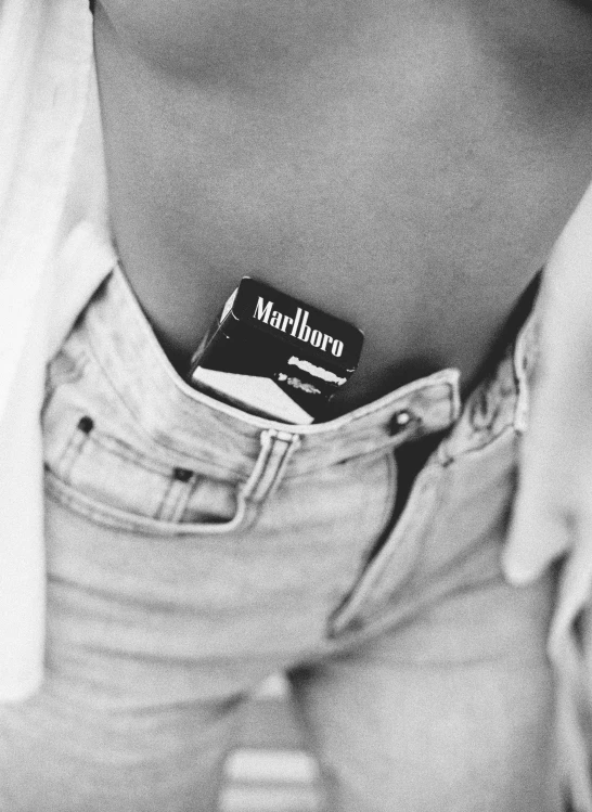 a black and white photo of a person with a cell phone in their pocket, a tattoo, inspired by Nan Goldin, unsplash, taking tobacco snuff, wearing a sexy cropped top, vintage levi ’ s ad, :: madison beer