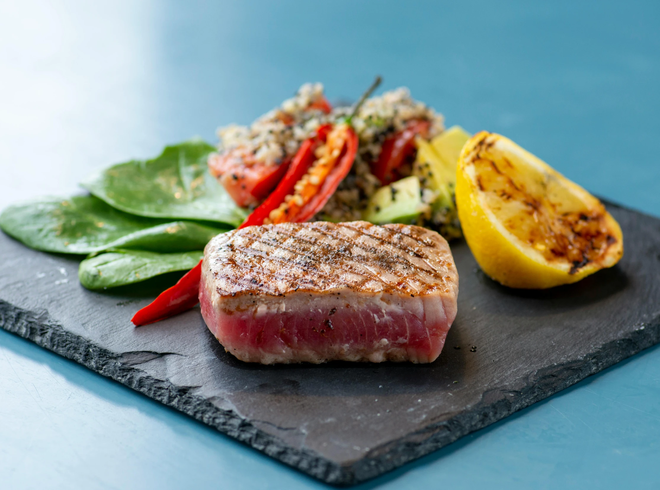 a piece of steak sitting on top of a slate plate, on the ocean, profile image