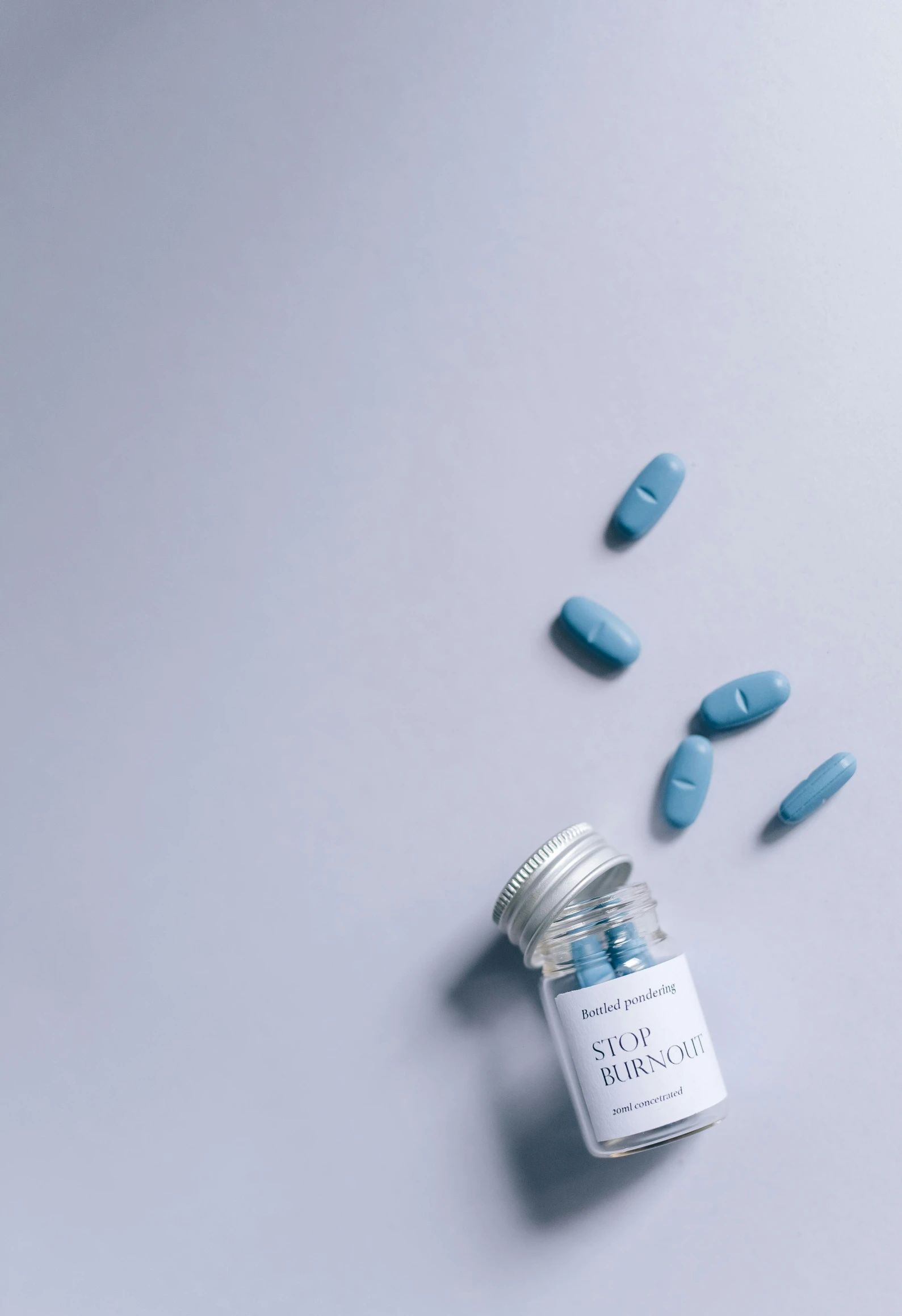 pills spilling out of a bottle on a table, unsplash, renaissance, blue and gray colors, multiple stories, product design shot, non-binary