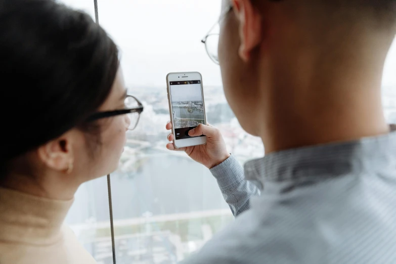 a man and a woman looking out a window at a city, pexels contest winner, mobile learning app prototype, close up to the screen, asian descend, 2 5 6 x 2 5 6 pixels