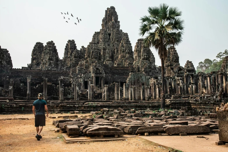 a man walking through the ruins of a temple, by Tom Wänerstrand, pexels contest winner, visual art, angkor, avatar image, ad image