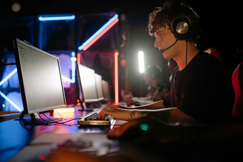 a man wearing headphones sitting in front of a computer, pexels, realism, tournament, server in the middle, thumbnail, (night)