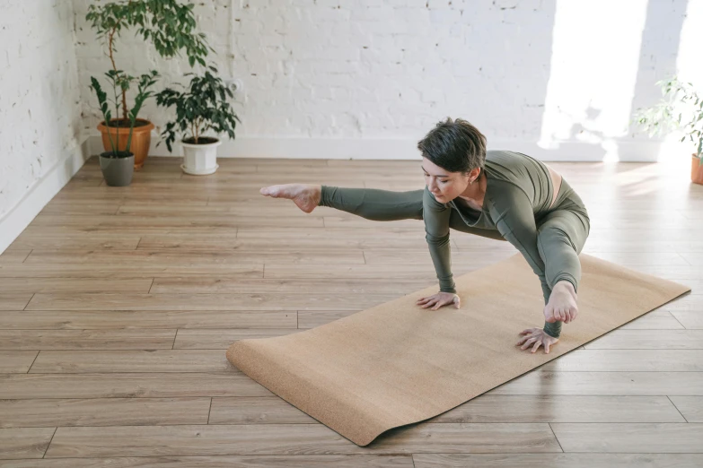 a woman doing a yoga pose on a yoga mat, pexels contest winner, arabesque, cardboard, brown, manuka, low quality photo