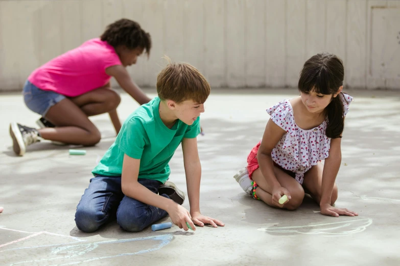 a group of children sitting on the ground drawing with chalk, by Arabella Rankin, pexels contest winner, interactive art, polished concrete, summer light, 15081959 21121991 01012000 4k, facing sideways