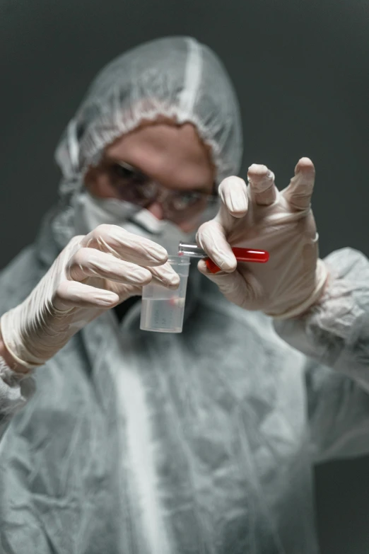 a man in a hazmat suit holding a pair of scissors, a microscopic photo, shutterstock, scratched vial, lgbtq, liquid metal, contain