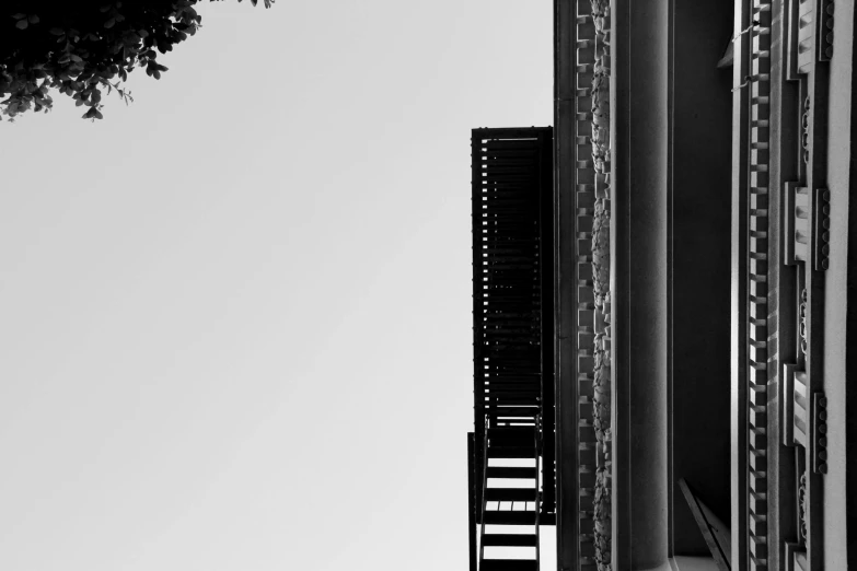 a black and white photo of a tall building, a black and white photo, inspired by André Kertész, pexels contest winner, postminimalism, outdoor staircase, today\'s featured photograph 4k, view from the side, shot on sony a 7