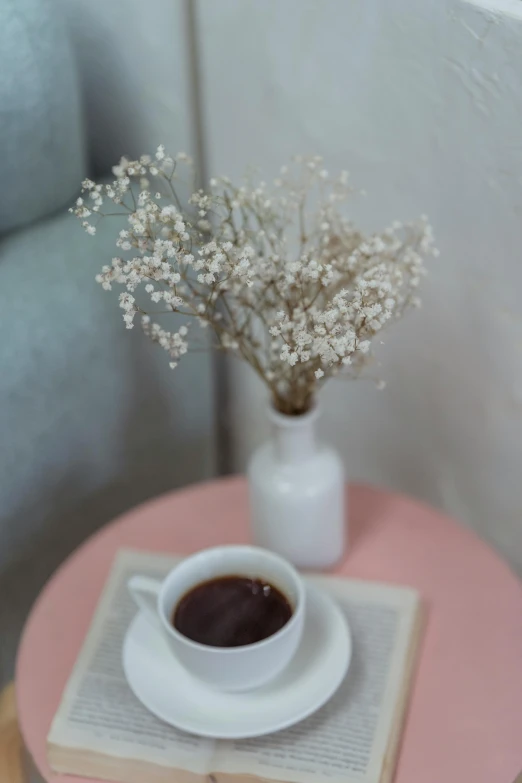 a cup of coffee sitting on top of a pink table, by Tan Ting-pho, romanticism, gypsophila, dark sienna and white, on a white table, simple details