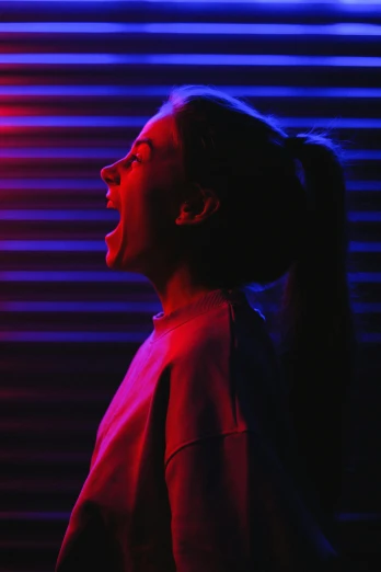 a woman standing in front of a neon light, pexels contest winner, yelling, red and blue black light, woman crying, grainy