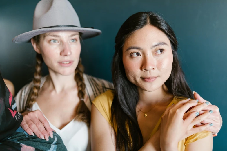 a couple of women standing next to each other, a portrait, trending on pexels, ruan jia and greg rutkowski, wearing a hat, relaxed eyebrows, avatar image