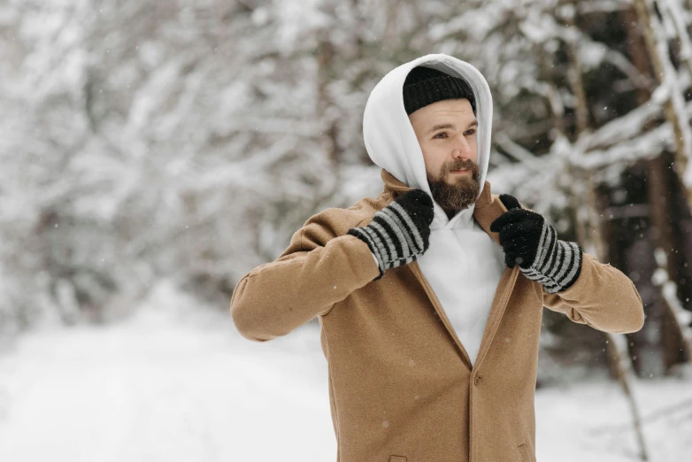 a man in a brown coat standing in the snow, wearing a cute hat, beard stubble, wearing gloves, avatar image