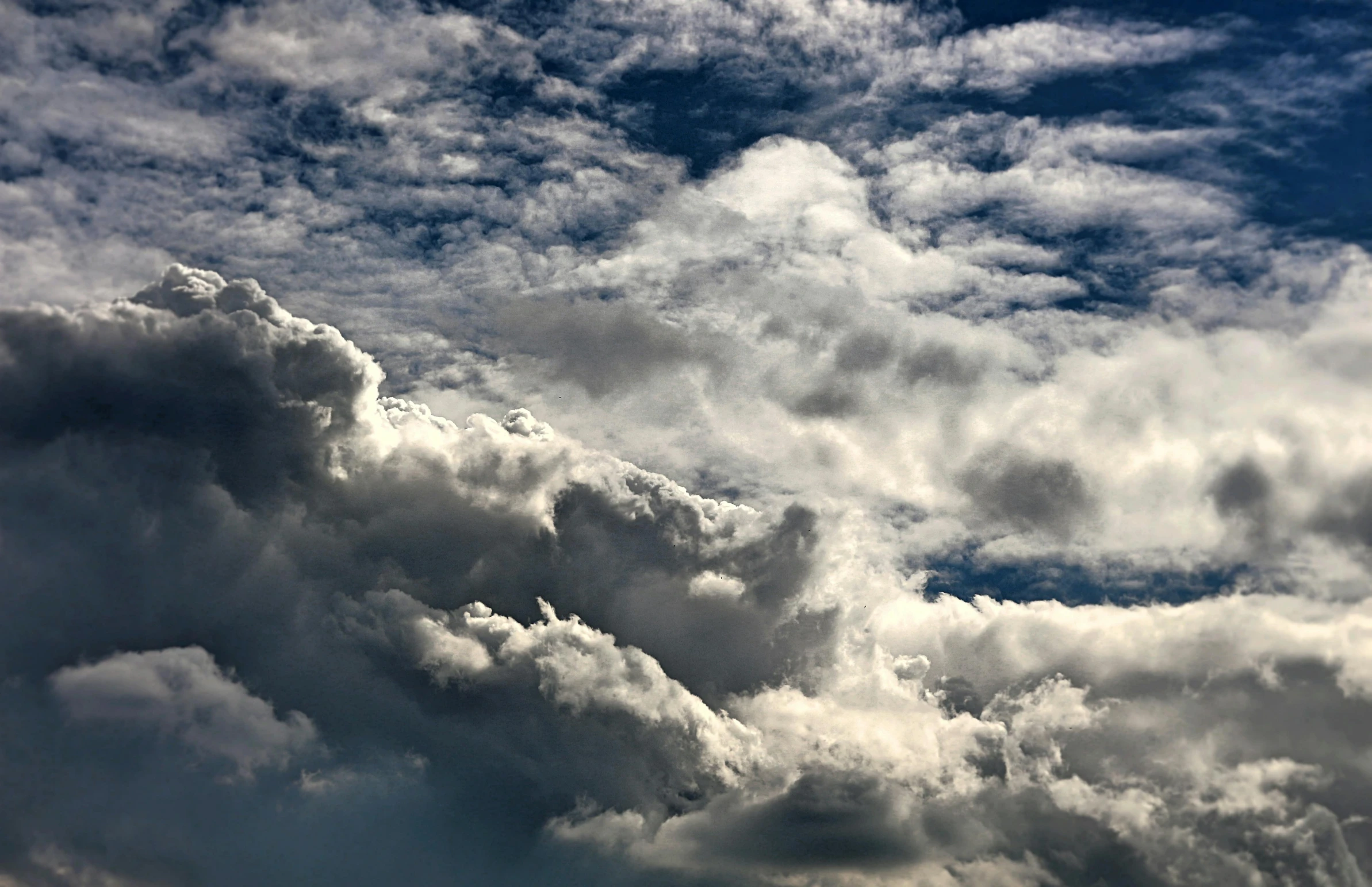 a plane flying through a cloudy blue sky, by Jan Rustem, pexels contest winner, romanticism, hyperdetailed storm clouds, “puffy cloudscape, grey, mixed art