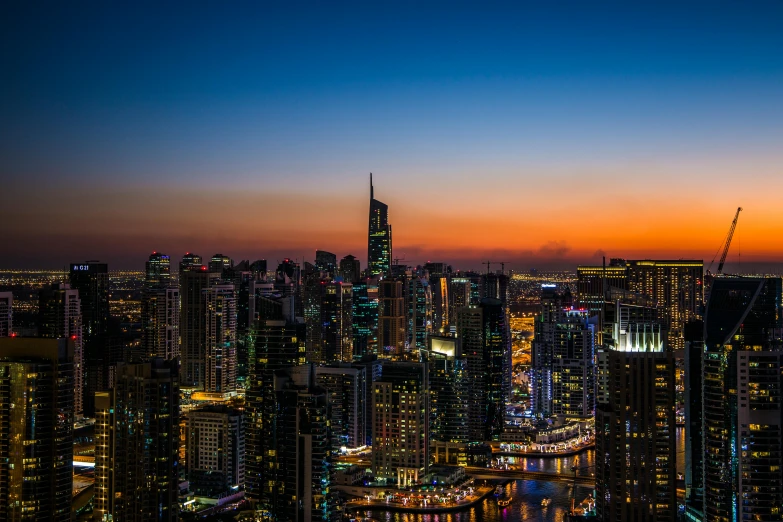 a view of a city at night from the top of a building, dubai, during a sunset, desktop wallpaper, multicoloured