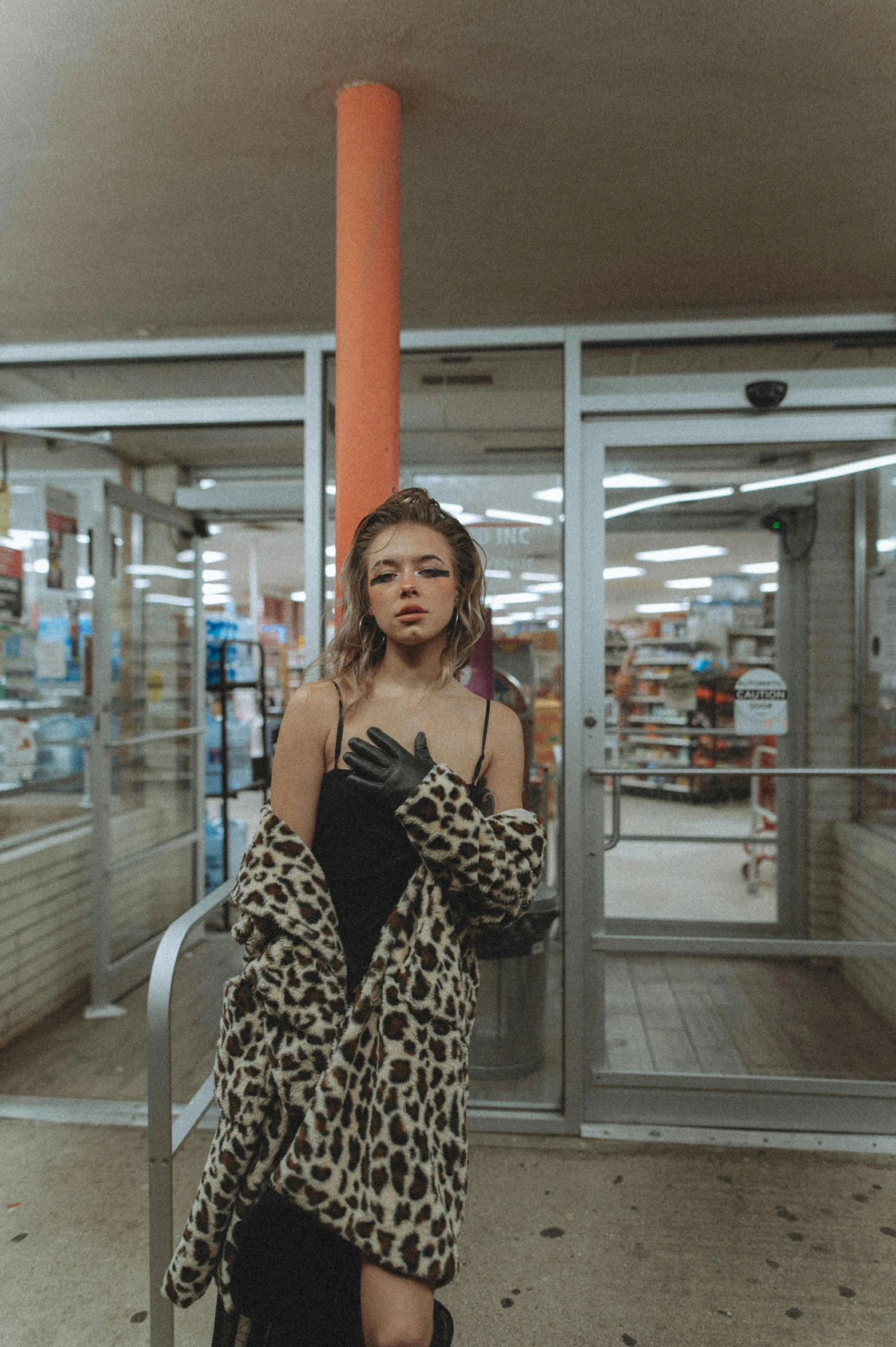 a woman standing in front of a store, an album cover, inspired by Elsa Bleda, trending on pexels, wearing animal skin clothing, stood in a supermarket, portrait sophie mudd, drugstore