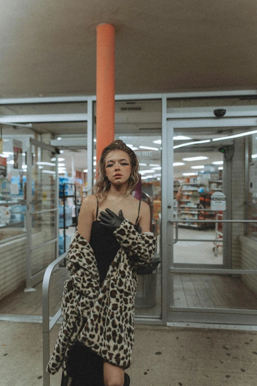 a woman standing in front of a store, an album cover, inspired by Elsa Bleda, trending on pexels, wearing animal skin clothing, stood in a supermarket, portrait sophie mudd, drugstore