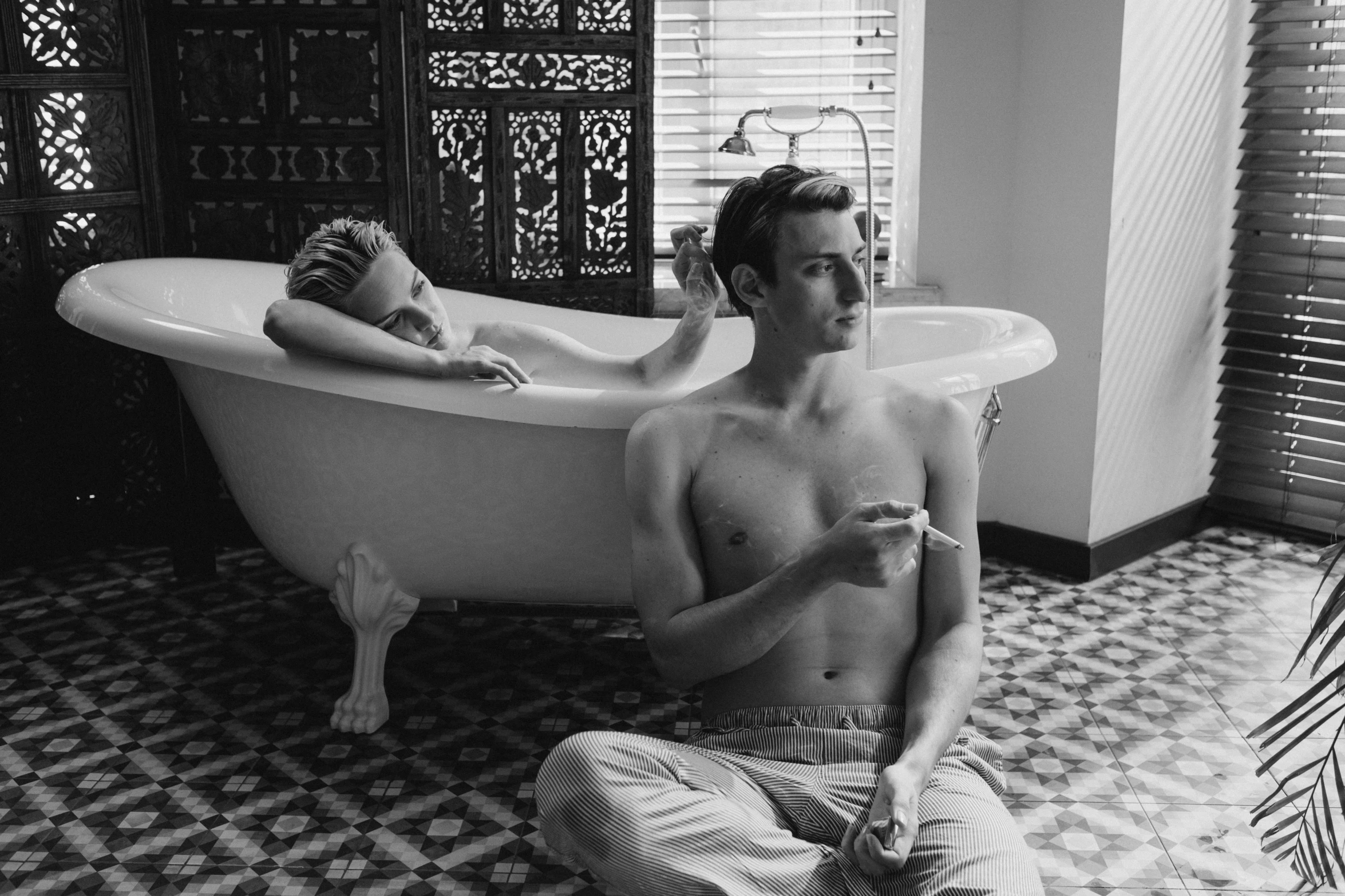 a man sitting on the floor in front of a bathtub, a black and white photo, inspired by Balthus, fine art, couple on bed, cai xukun, ffffound, die antwoord