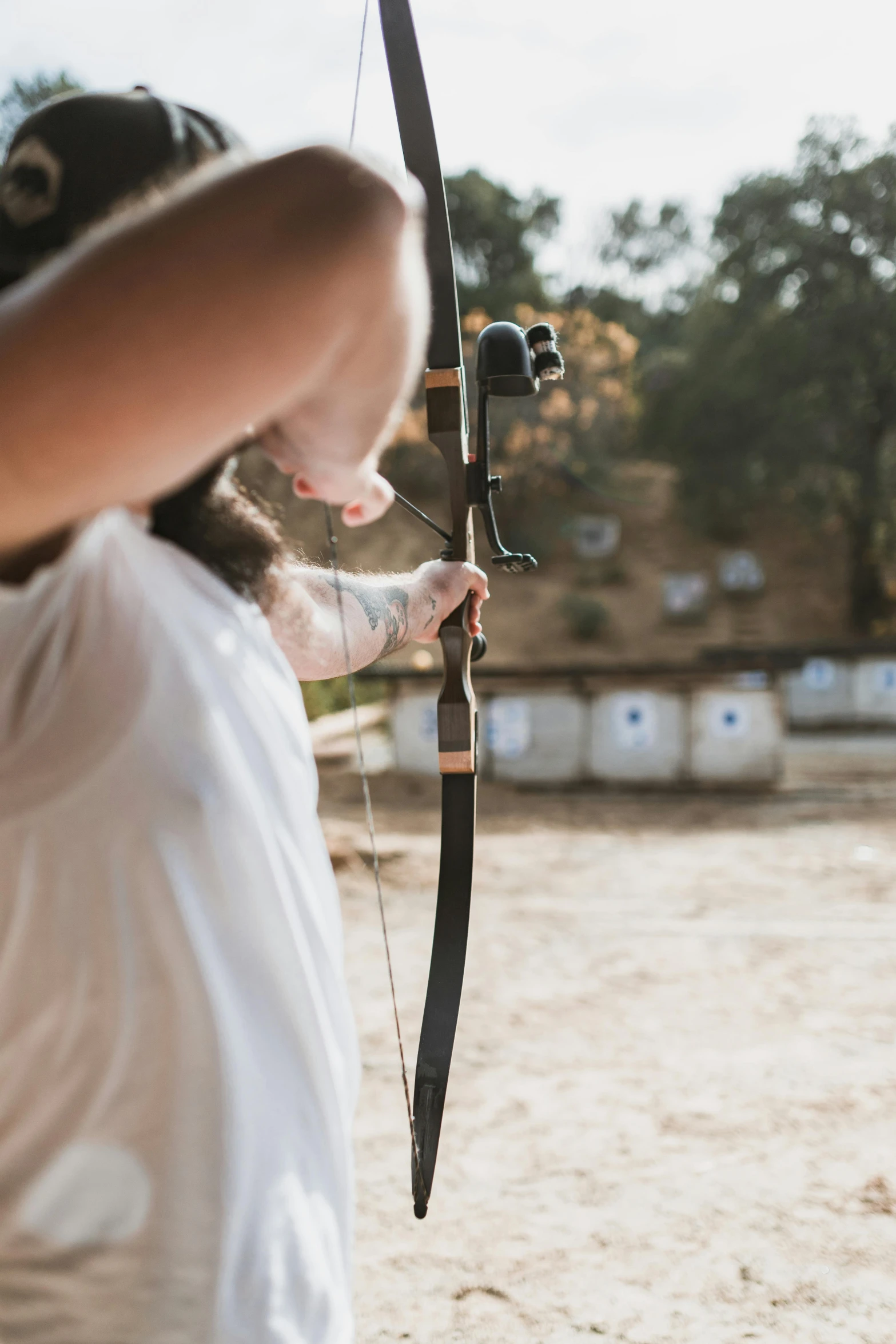 a woman aiming a bow at a target, pexels contest winner, photo of a man, subtle detailing, outside, unfinished