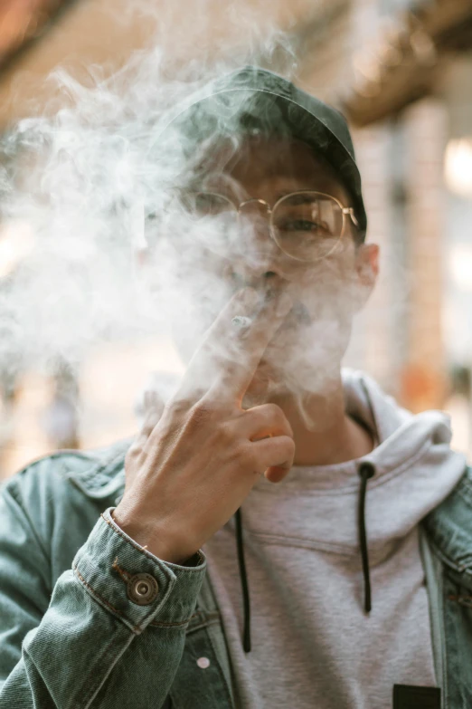 a man smoking a cigarette on a city street, pexels contest winner, giving the middle finger, mist vapor, pot leaf, wearing sunglasses and a cap