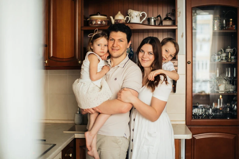 a man and woman holding a child in a kitchen, a picture, by Julia Pishtar, pexels contest winner, ukraine. professional photo, group photo, 15081959 21121991 01012000 4k, fan favorite