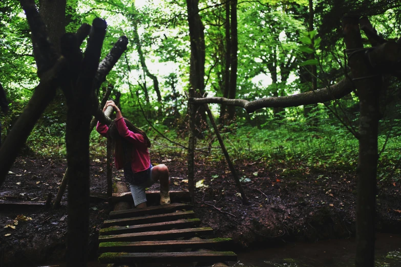 a person standing on a wooden bridge in the woods, inspired by Elsa Bleda, unsplash, process art, adventure playground, coming down the stairs, soaking wet, 2 5 6 x 2 5 6 pixels