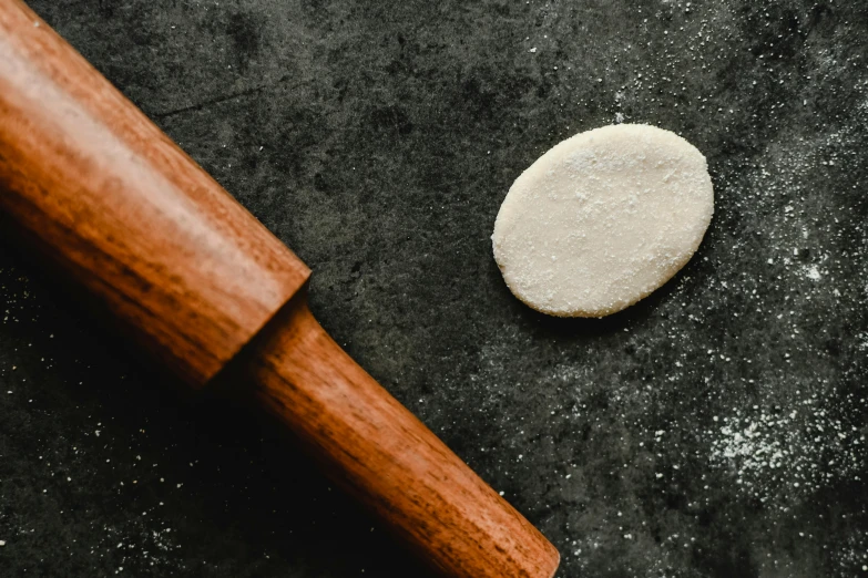 a rolling pin sitting on top of a table next to a cookie, inspired by Richmond Barthé, unsplash, smooth concrete, shepherd's crook, thumbnail, eguchi