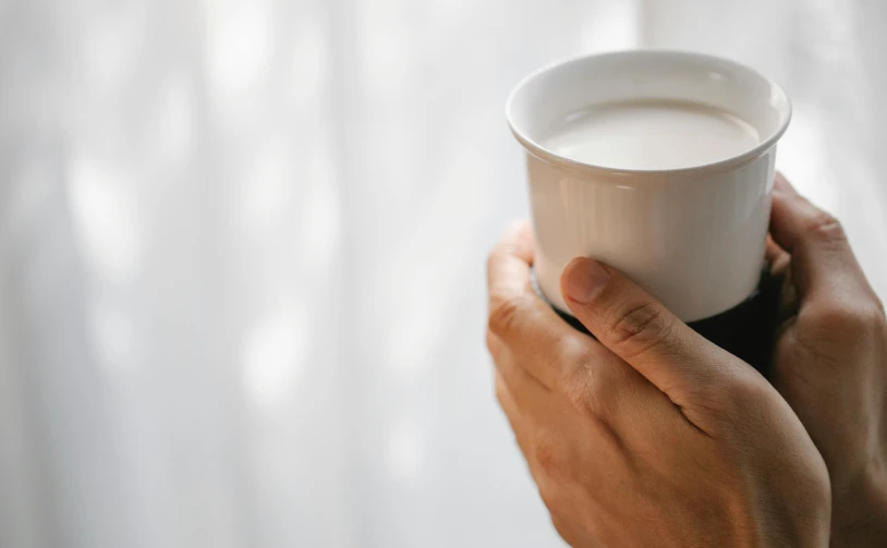 a close up of a person holding a cup of coffee, inspired by Kanō Tan'yū, minimalism, pale milky white porcelain skin, easy to use, hydration, round-cropped